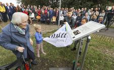 Tini Westerhof-Hartman onthult het monument ter nagedachtenis aan haar overleden ouders, broertje en zusjes bij de Friese sluis