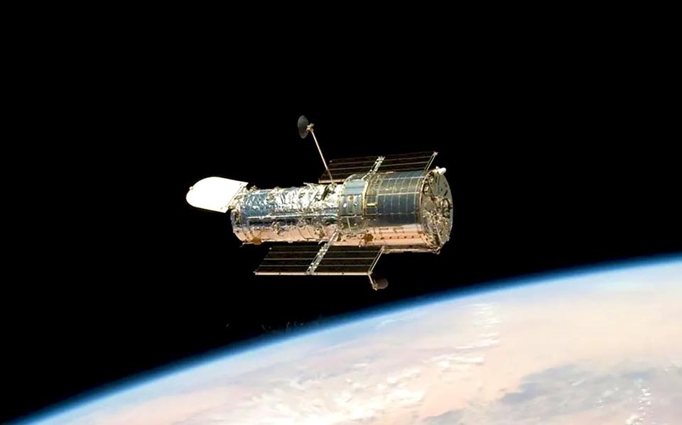 De Hubble-ruimtetelescoop hoog boven de aarde (foto vanuit shuttle Atlantis, 2009).